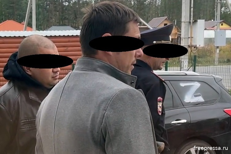 Сотрудники полиции на частной территории многодетного журналиста разглядывают фронтовой флаг батальона "Восток" (ДНР)